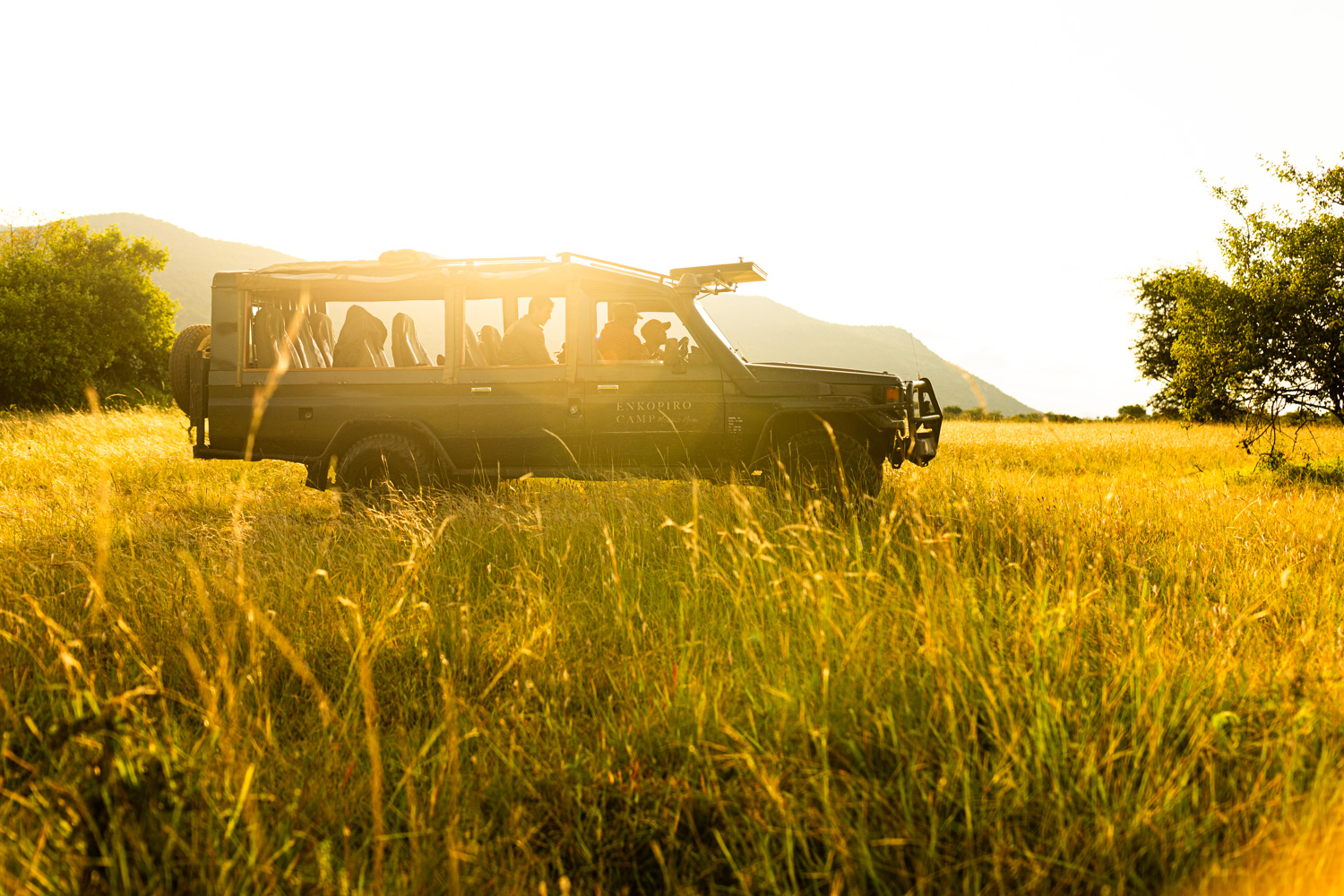 Sunset safari in Masai Mara National Reserve, Kenya. Safari vehicle from Enkopiro Masai Mara Camp during a wildlife photography and tourism filmmaking production by Aitor Lamadrid.